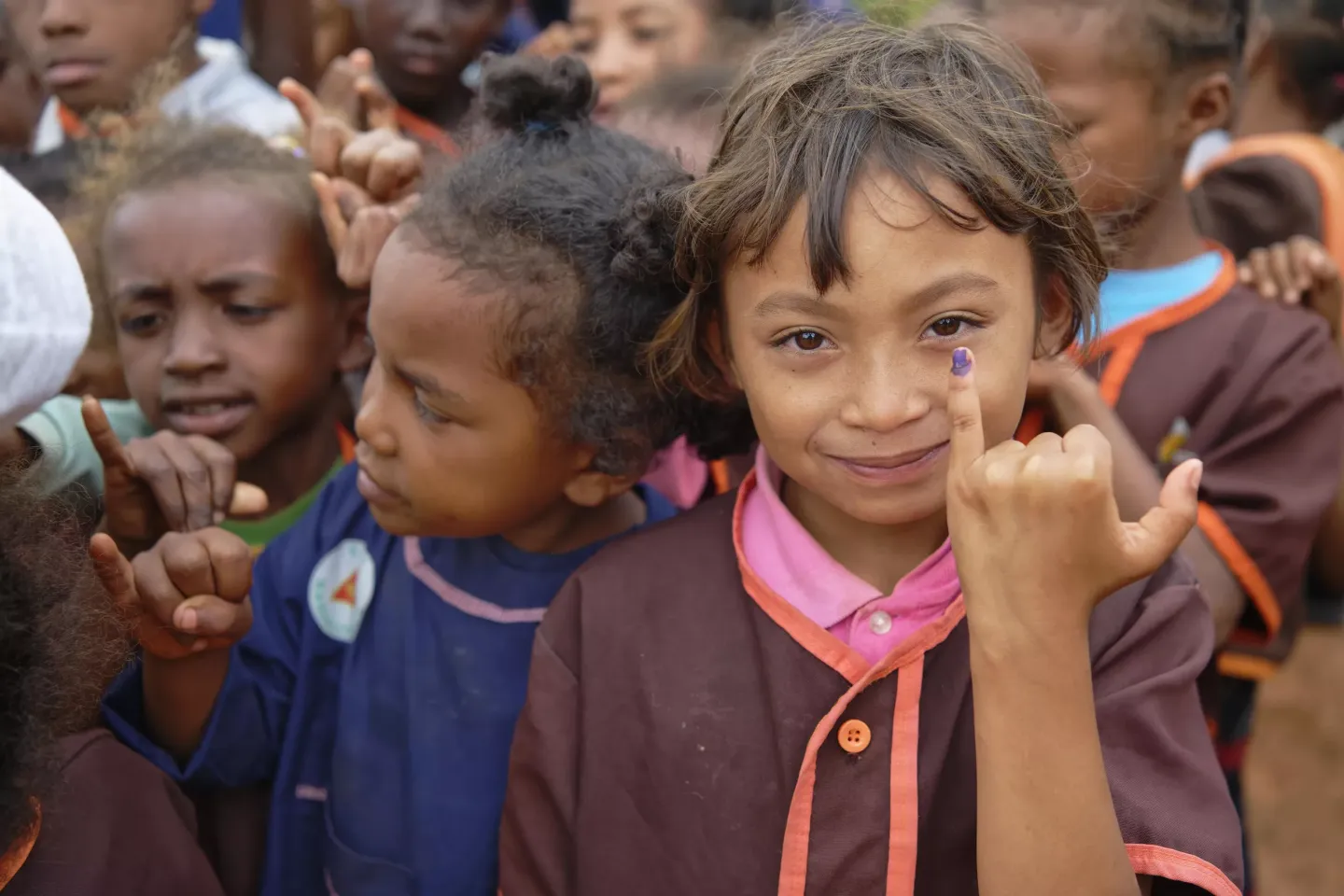 portrait of a little girl showing her little finger marked with ink to signify that she has been vaccinated against polio