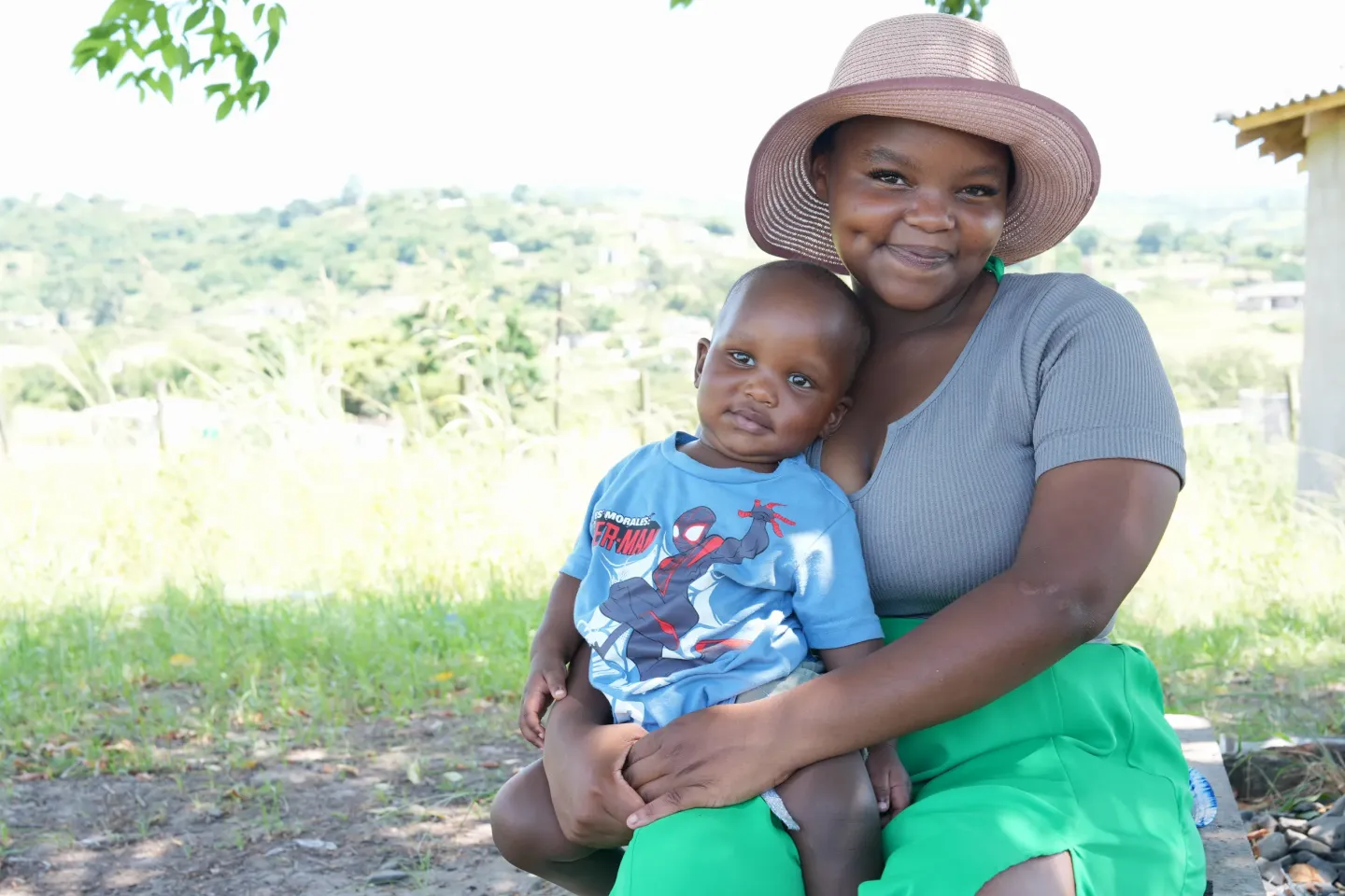 A woman holds a young child on her lap