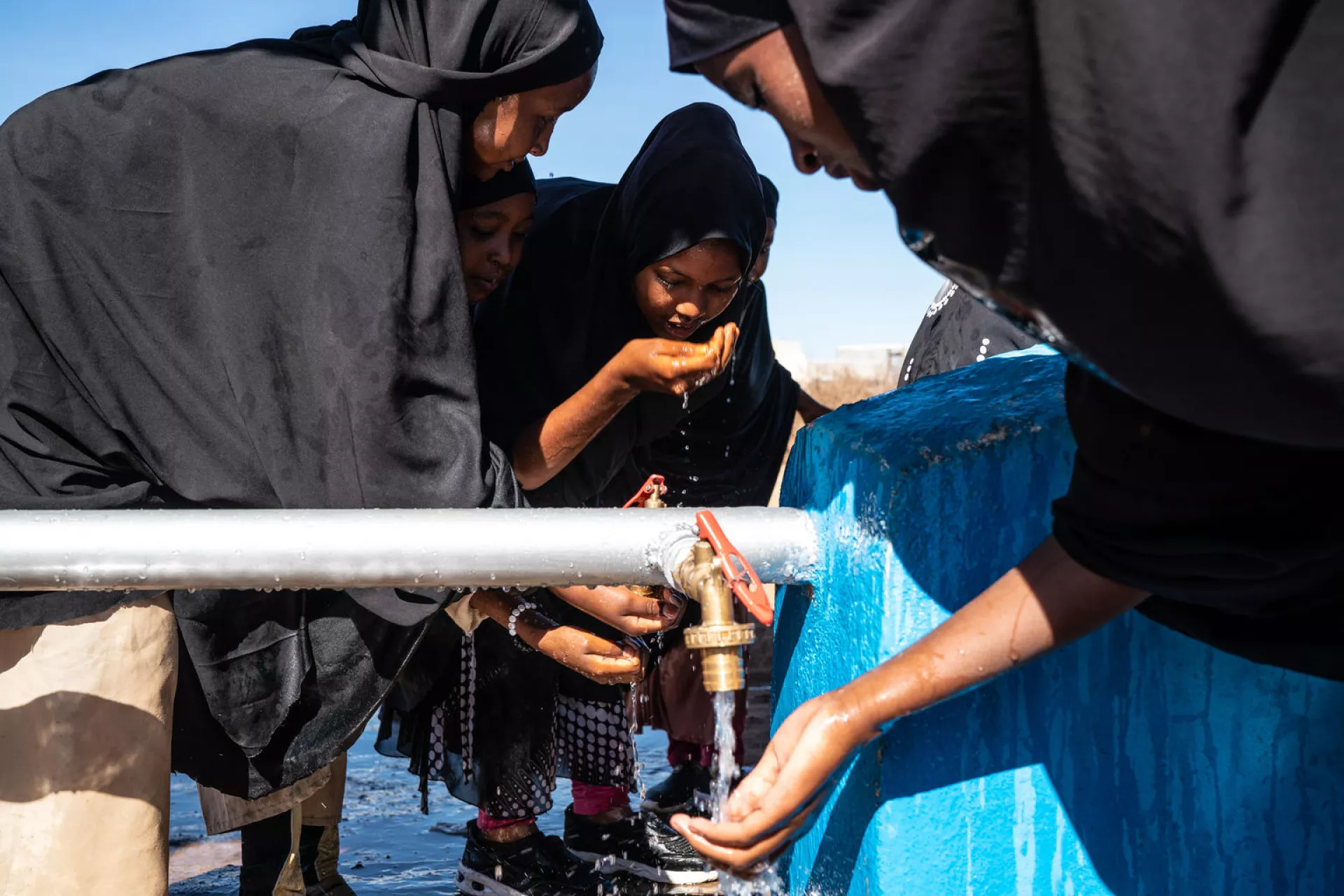 Young girls wash their hands at an EU-funded, UNICEF-supported water point in Somaliland.
