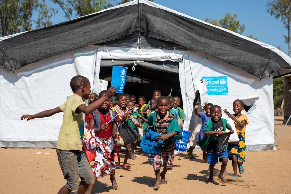 Children flowing out of a temporary learning facility