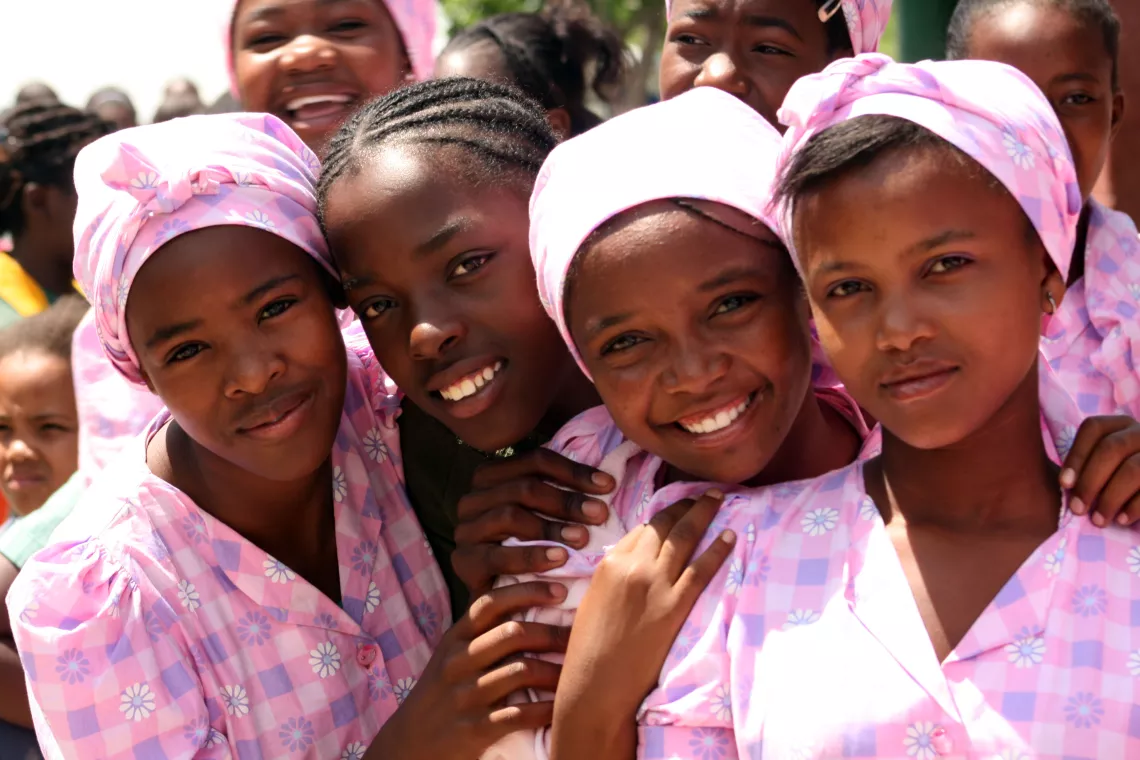 A group of adolescent girls pose and smile.