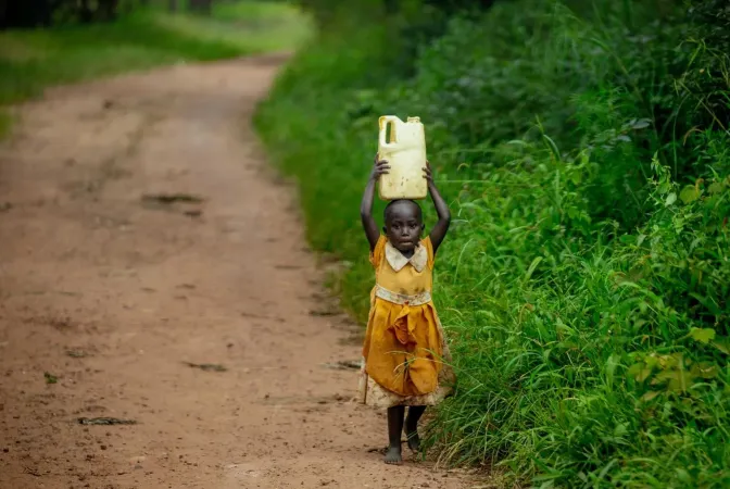 A portrait of a young girl returning home after fetching water