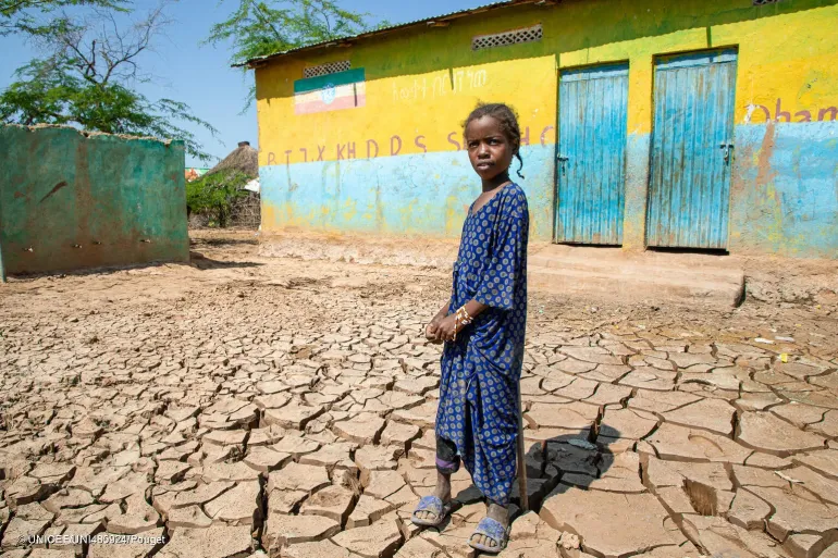 9-year-old Bintu stands outside a building.  Flooding in the Somali region of Ethiopia shut down her school, jeopardising her dream. 