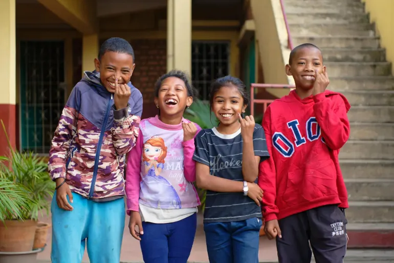 Group photo of schoolkids showing their little fingers marked with ink to signify that they have been vaccinated during the third day of the polio campaign.