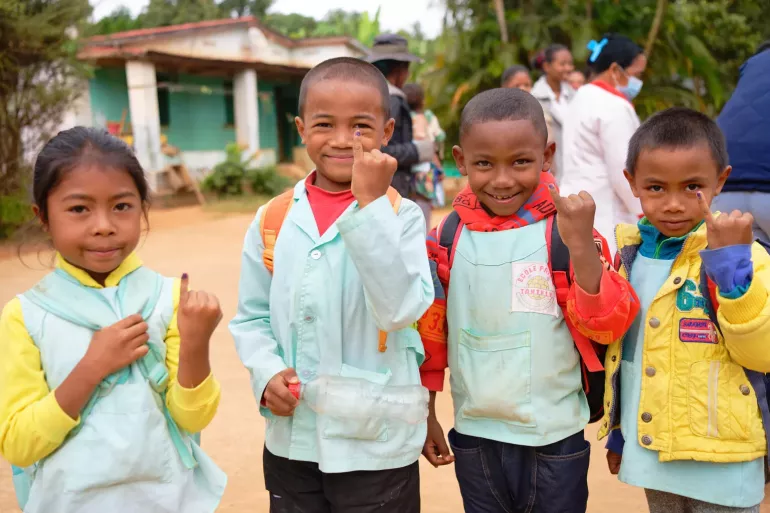 A group photo of school kids showing their little finger marked with ink to show that they have received their polio vaccine.