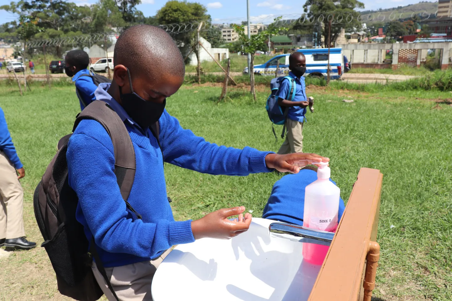 One person outdoors washing hands 