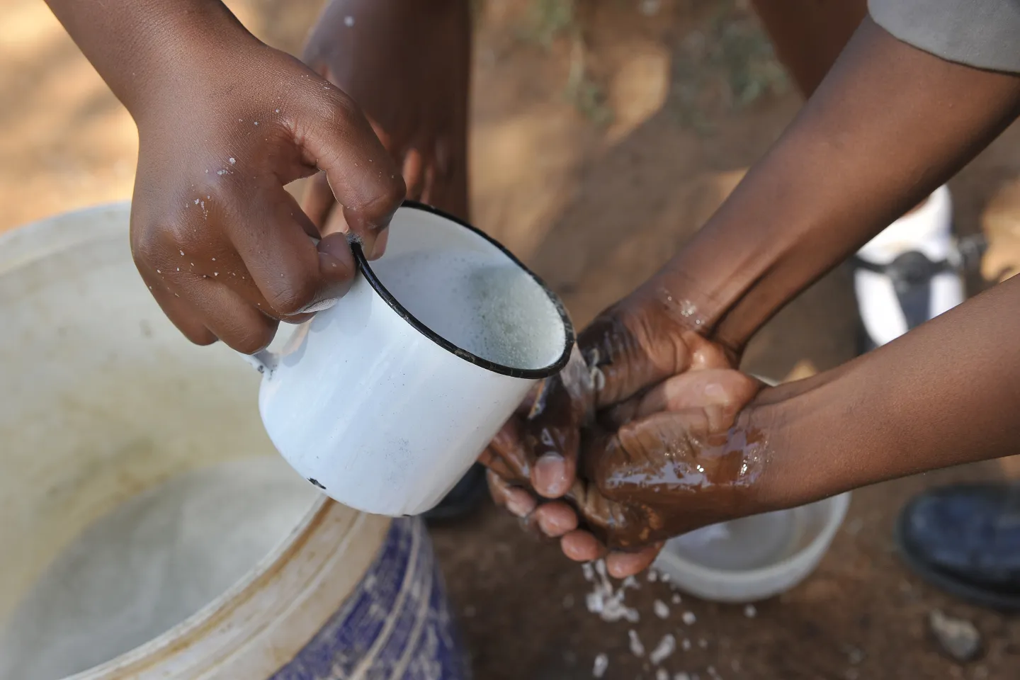 School children washing hands with soap and running water 