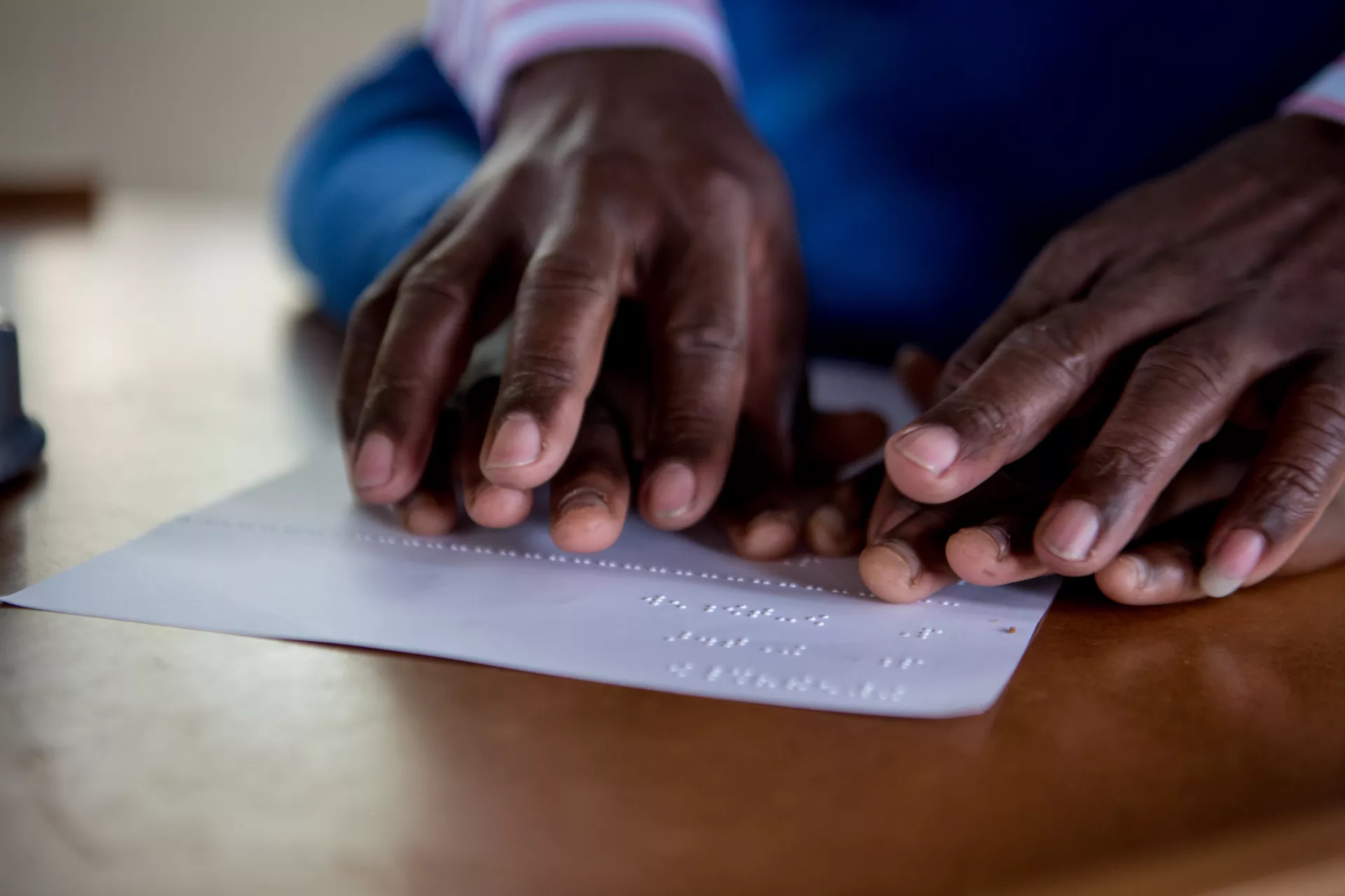A teacher helping a student to read braille 