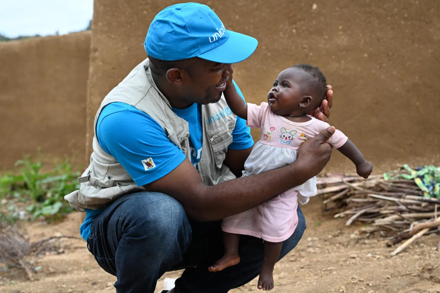 A UNICEF staff member in Cameroon plays with a little girl at the site of former hostages in Zamay.