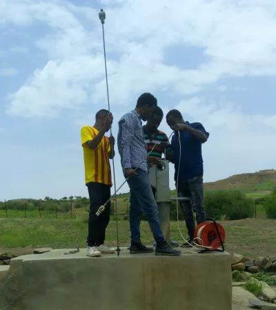 Alamerew, junior geologist from the Regional Bureau of Water (on the very right) takes measurements as part of his on-the-job training within the climate-resilient groundwater mapping project, Wag Himra Zone, Amhara 