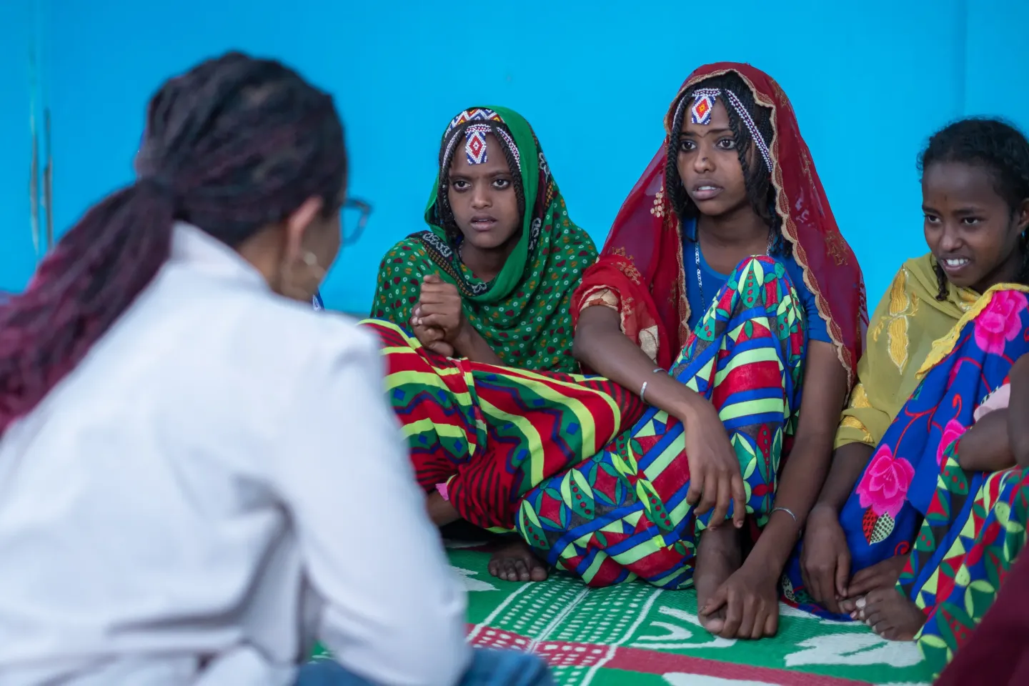 Young girls sitting in a round and discussing