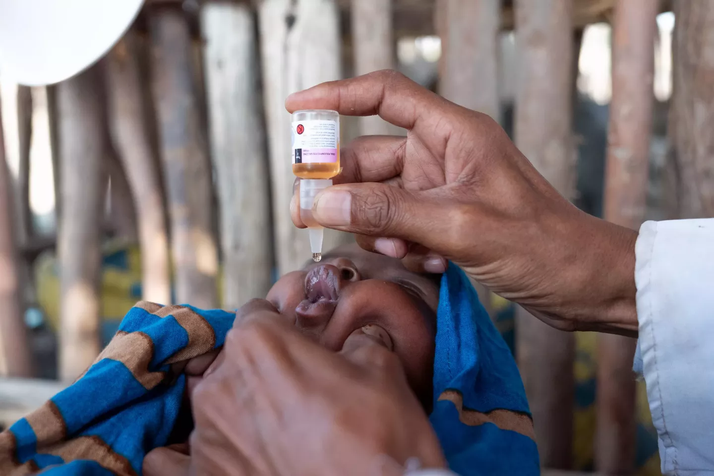 A child taking drops of oral polio vaccine.