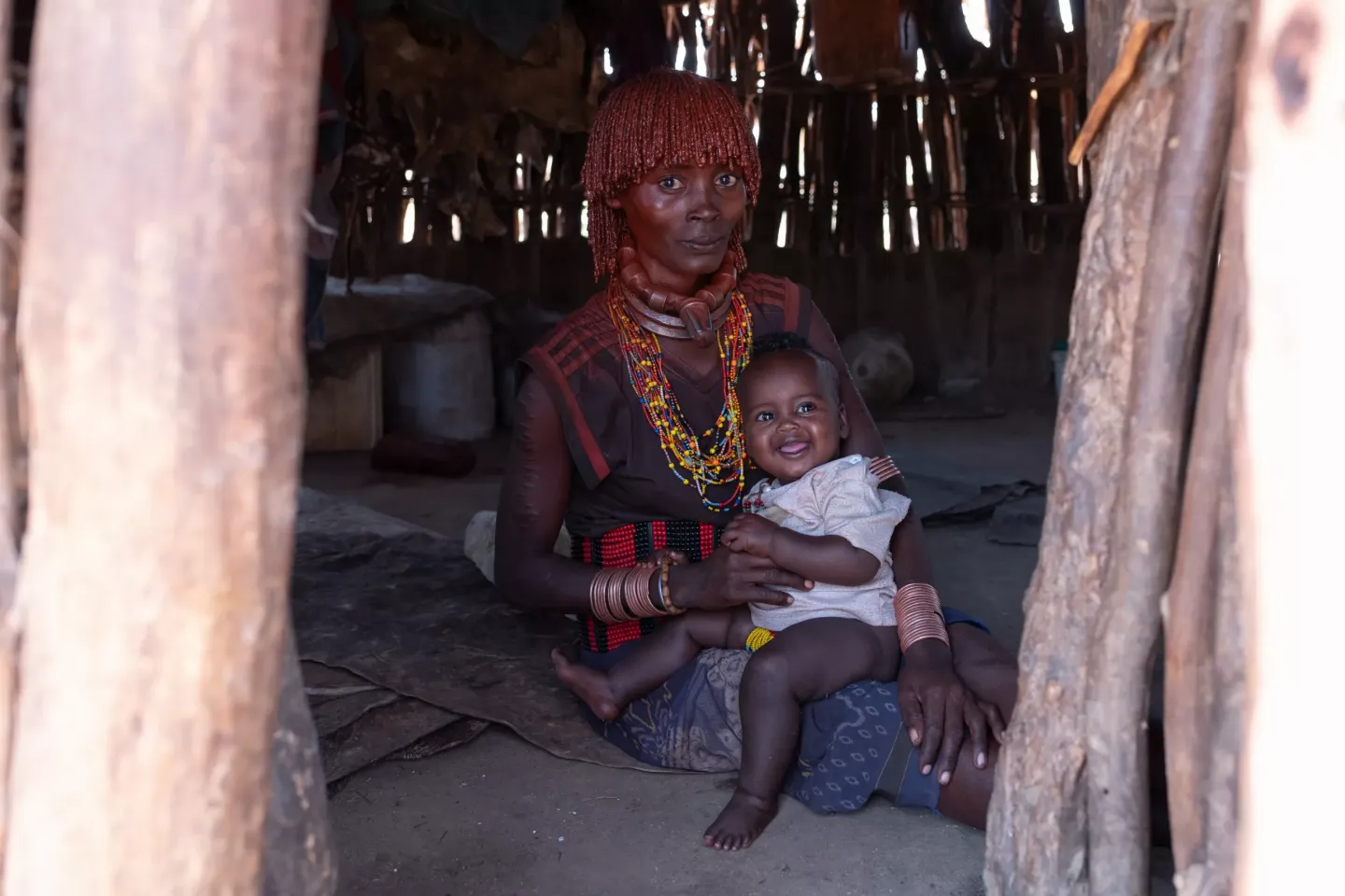 A mother sits while holding her six months old daughter. 