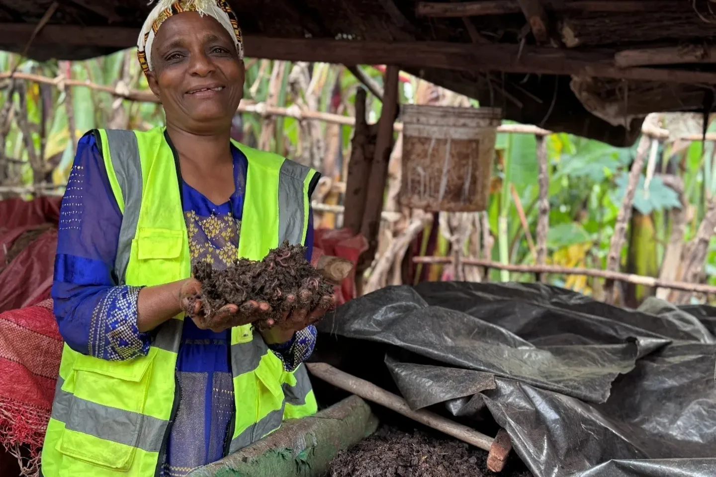 A women  holding a vermicompost from one of the stages in her hand and showing it to the camera