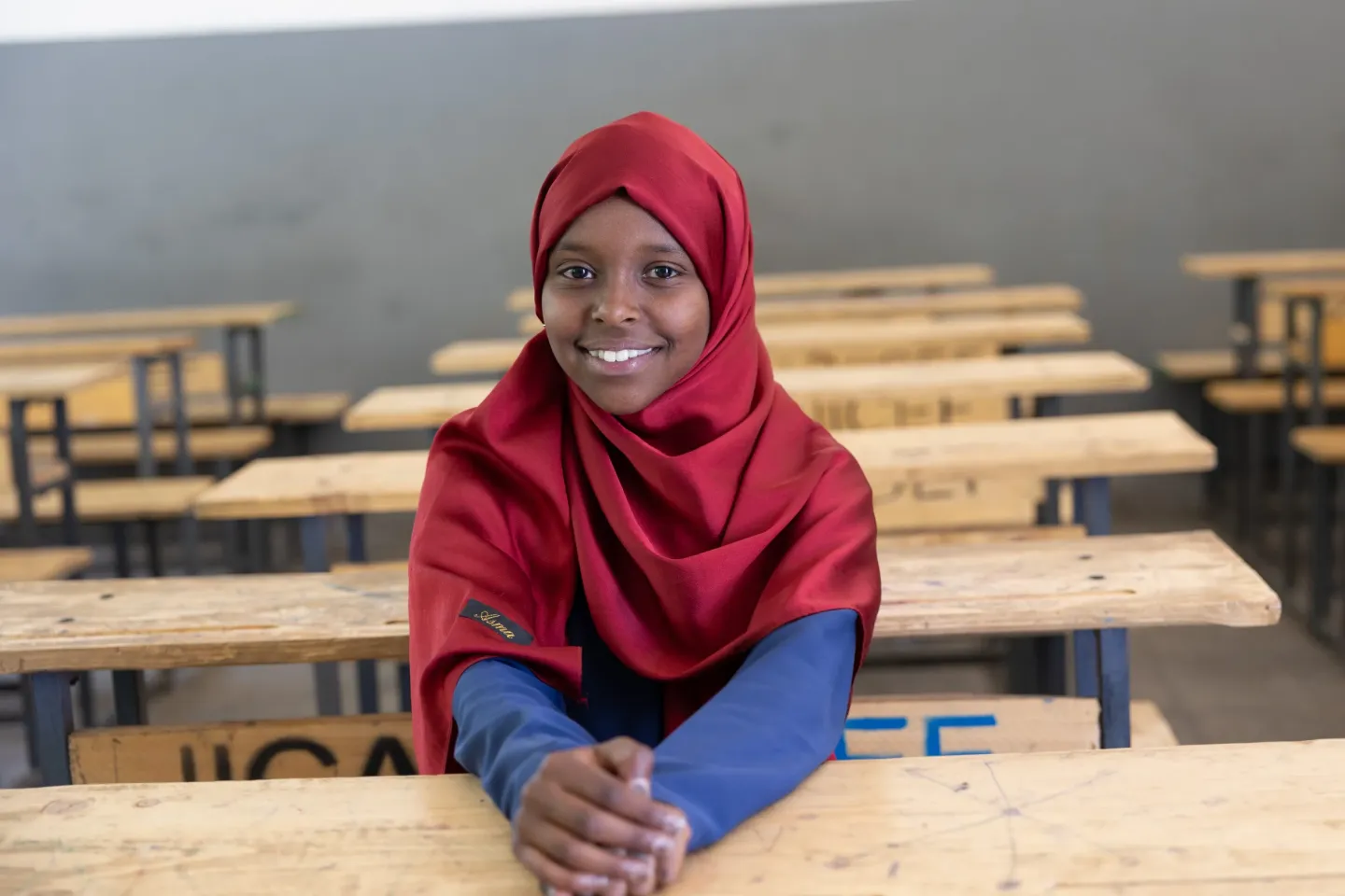 A young girls sits in a classroom