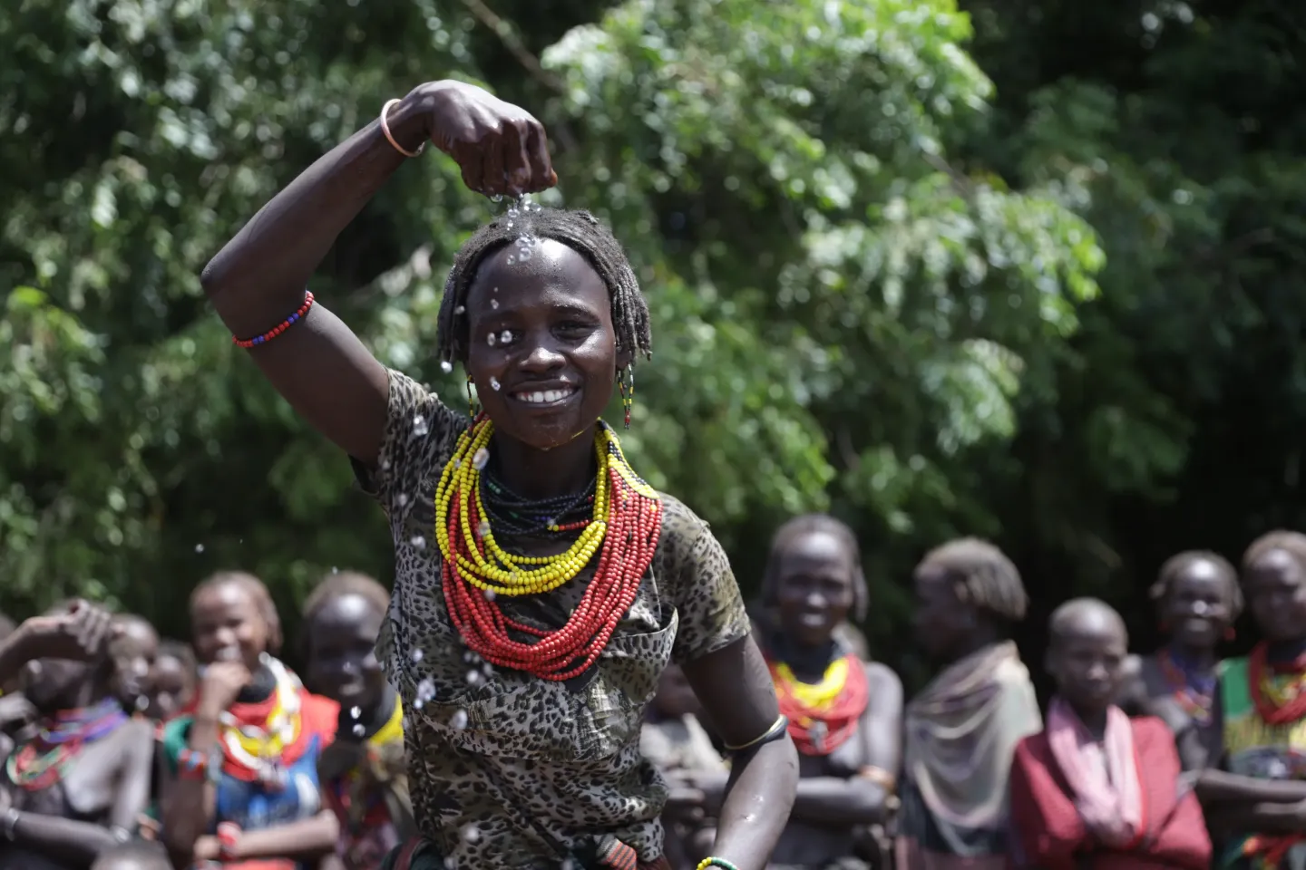 A little girl putting water on her face