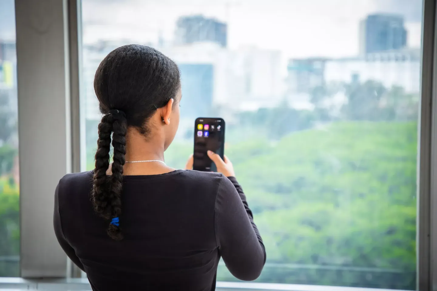 A young girl showing her back while holding her photo