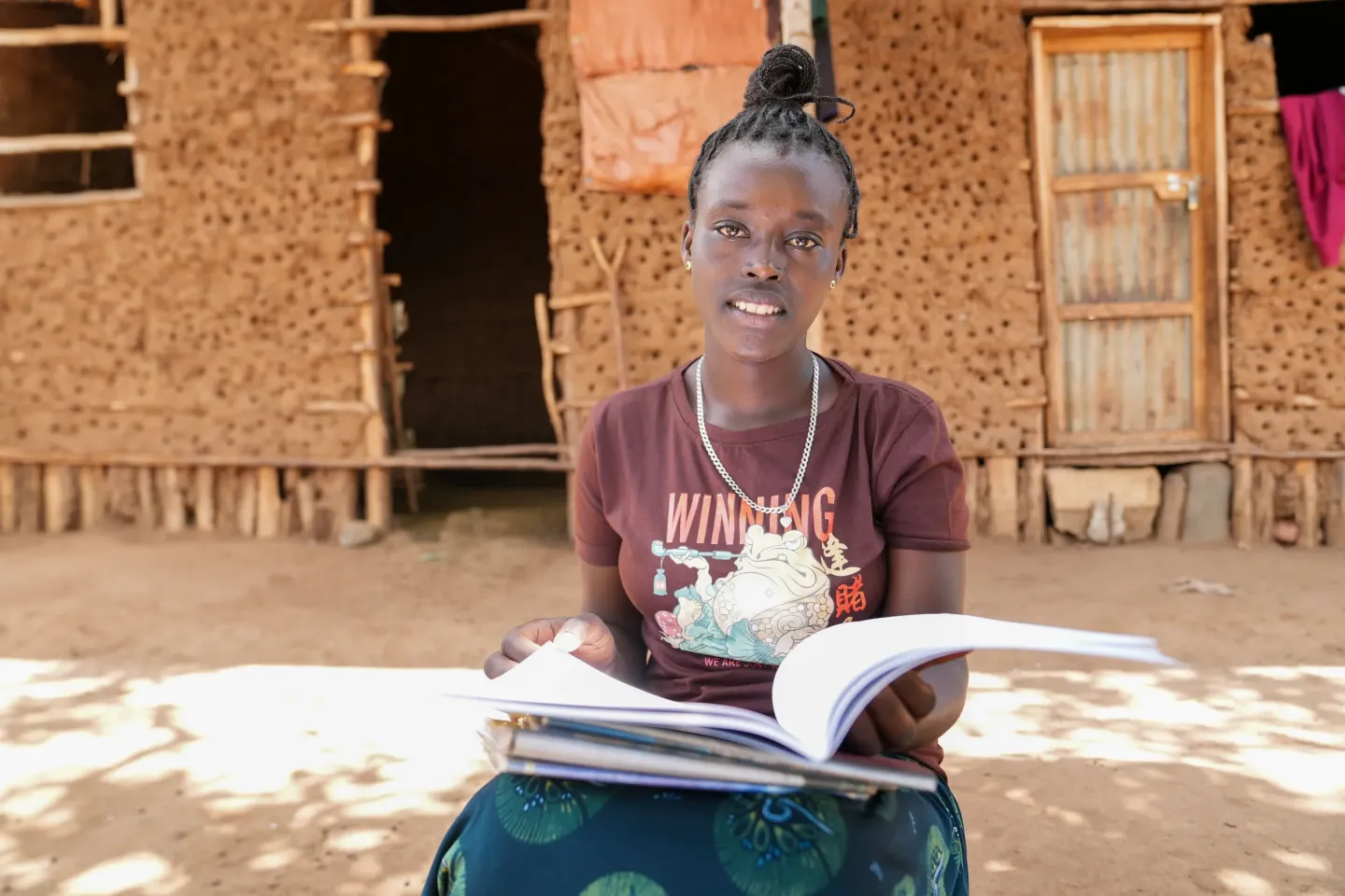 A young girl holding her note book in her hand