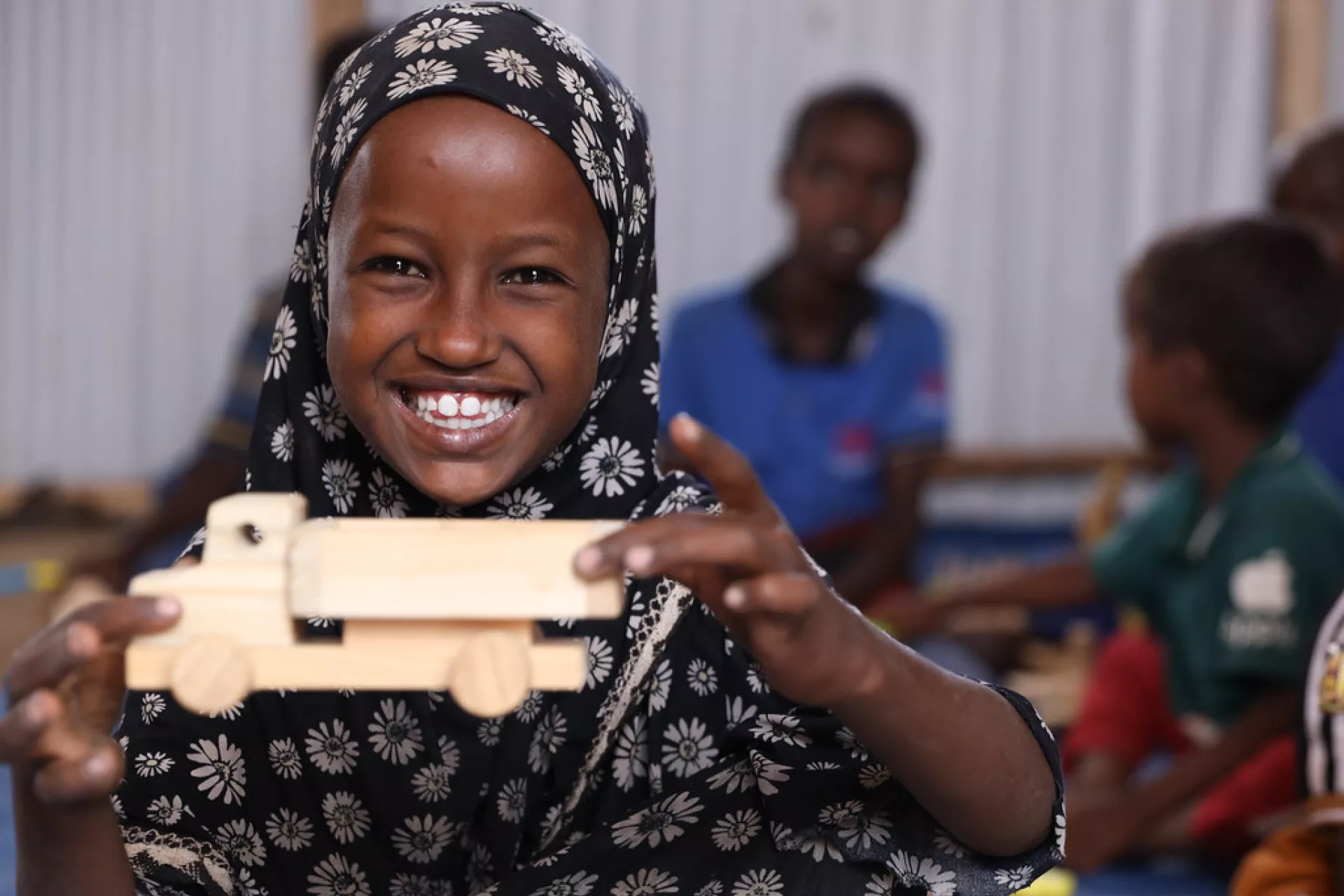 A girl child playing with a toy car  