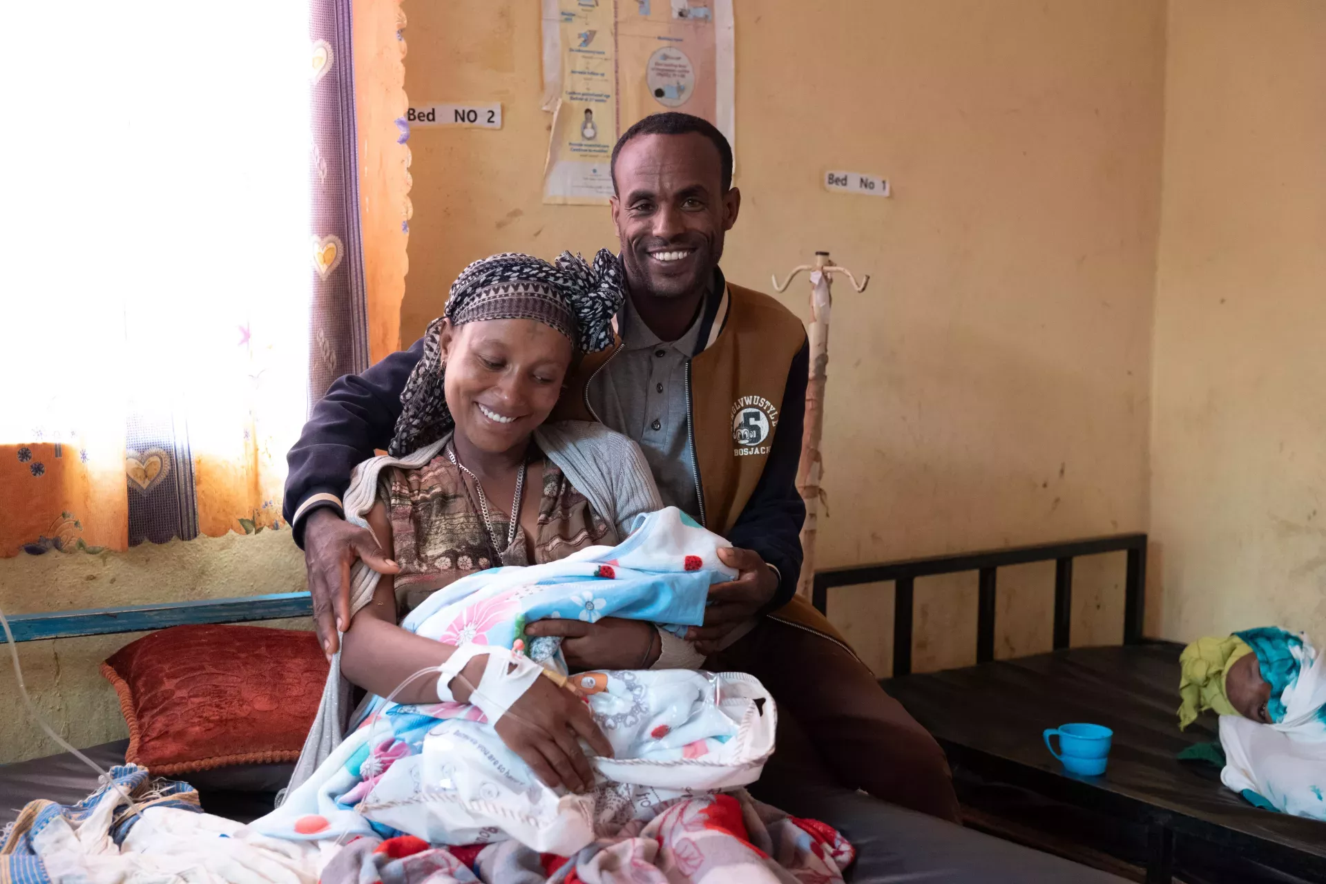 A mother and a father holding their new born baby. 