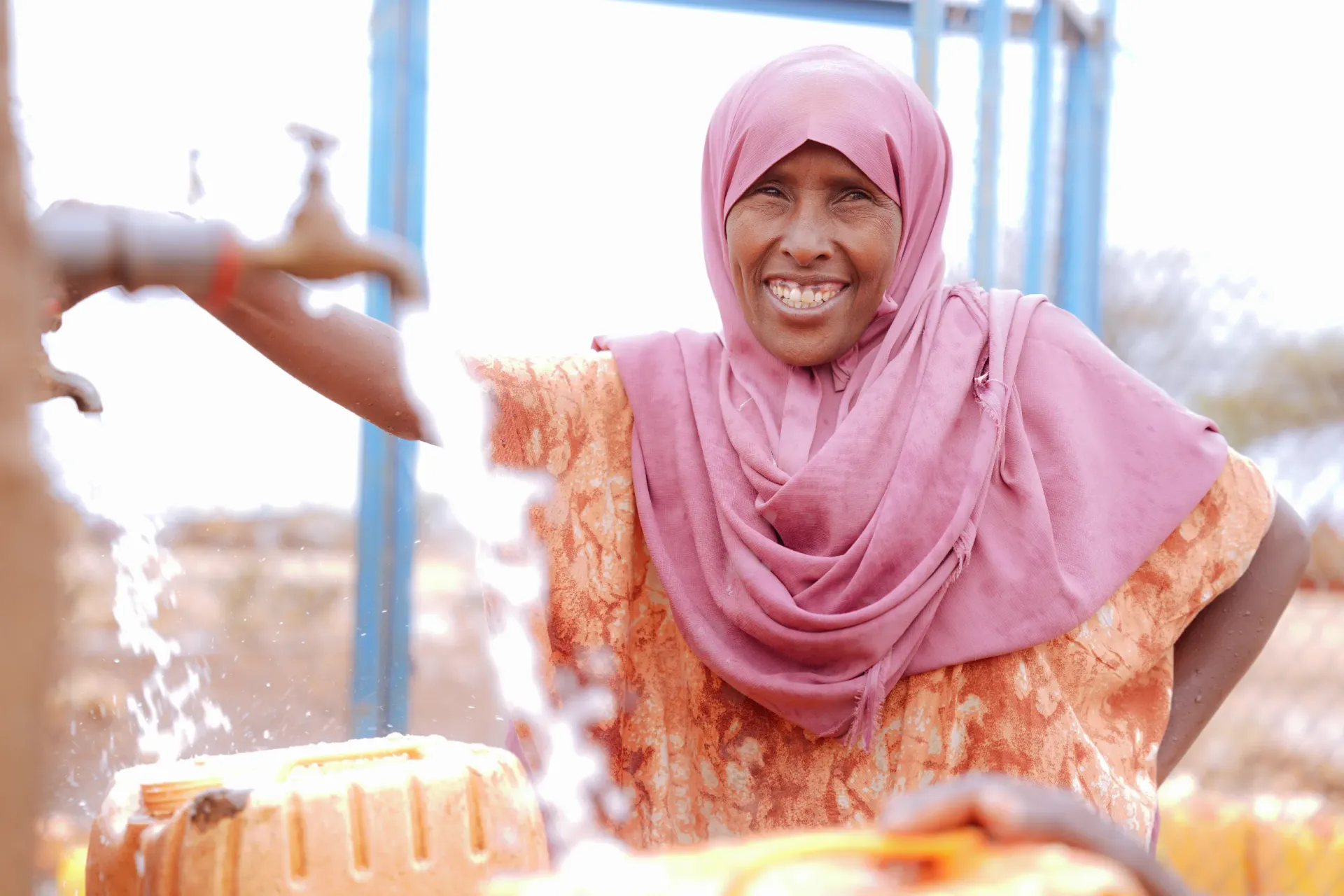 A women fetching water form nearby water system