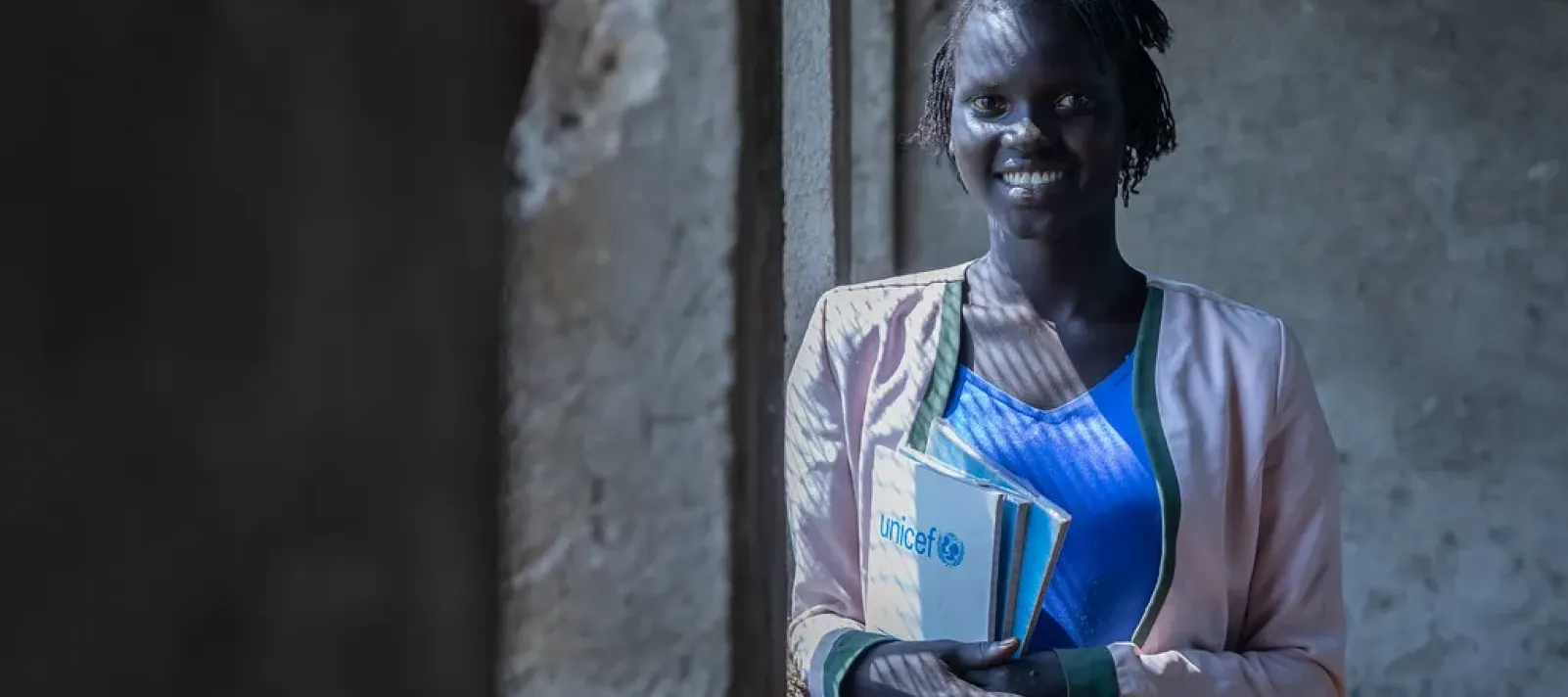 Refugee girl holding her notebook on close to her chest 