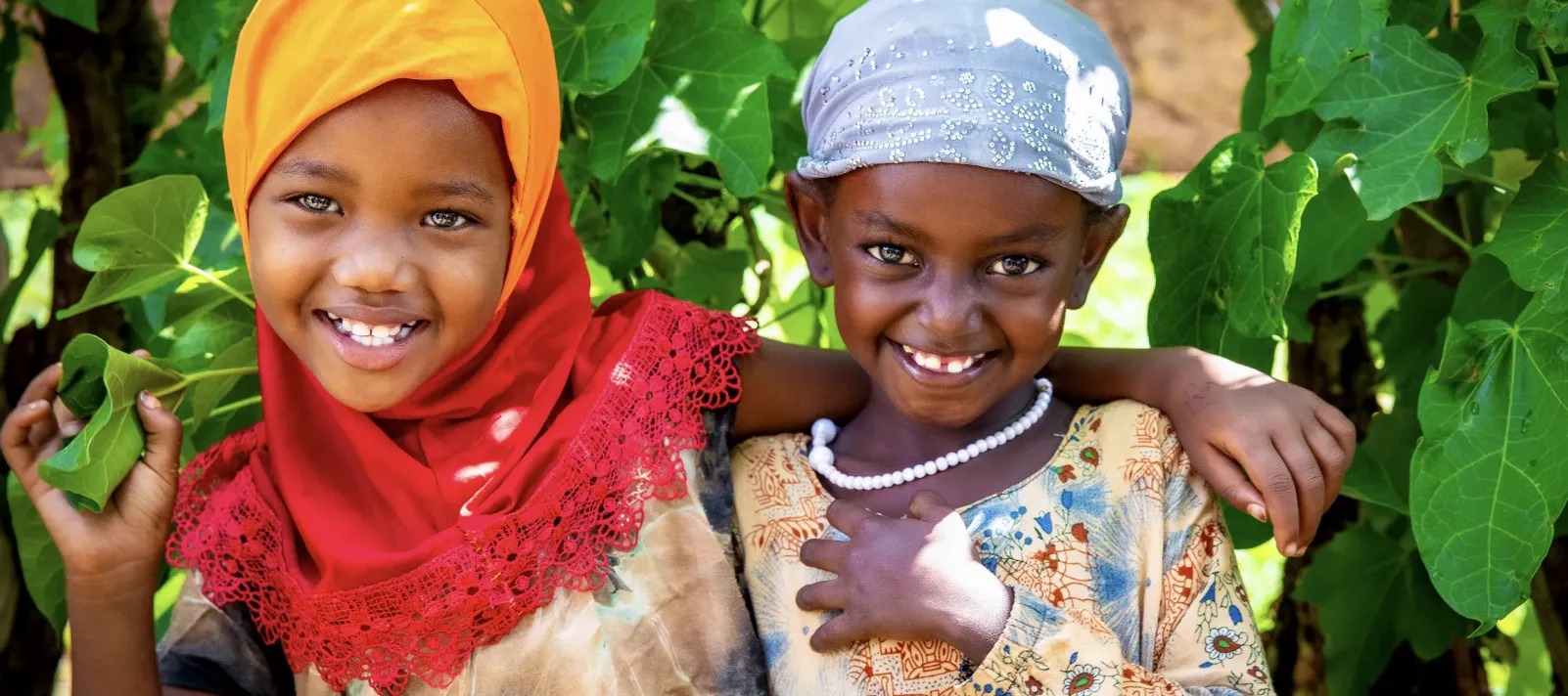 Two little girl hugging each other and posing for the camera