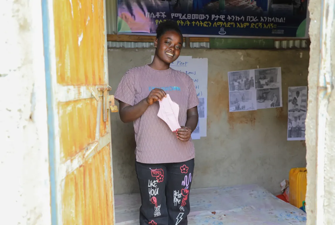 Meskerem holding a reusable sanitray pad in her school's MHH room