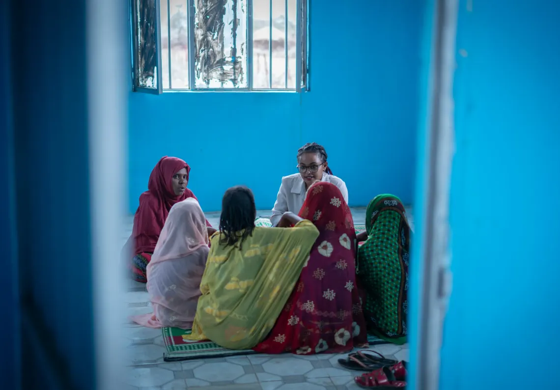 Young girls sitting in a round and discussing