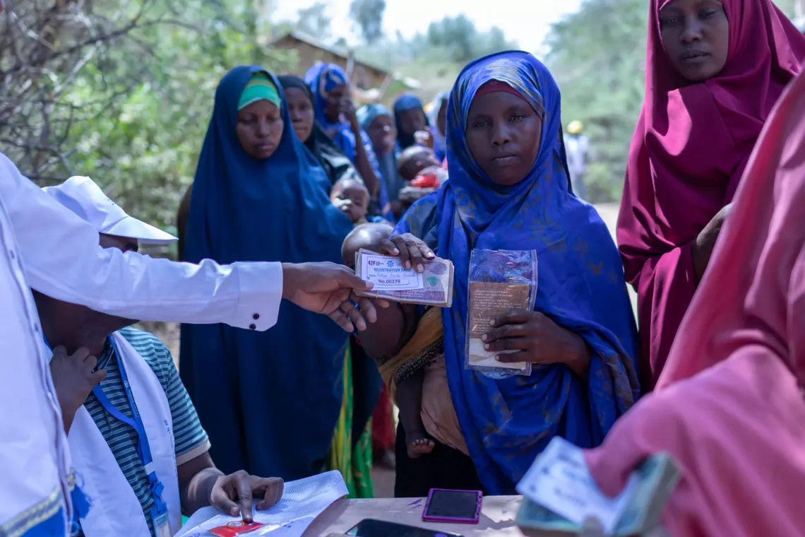 Group of women waiting in line to recieve cash support