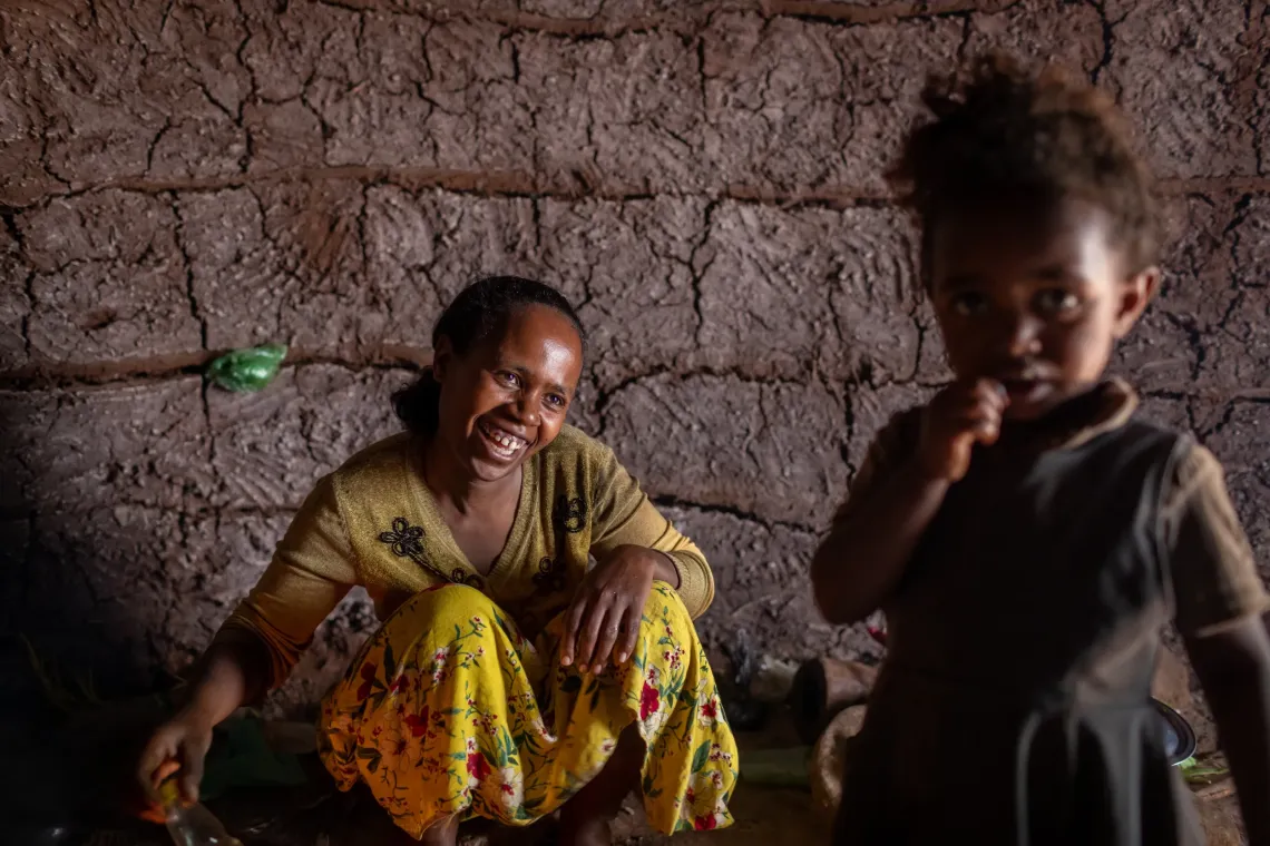 A woman smiles looking happily her daughter. 