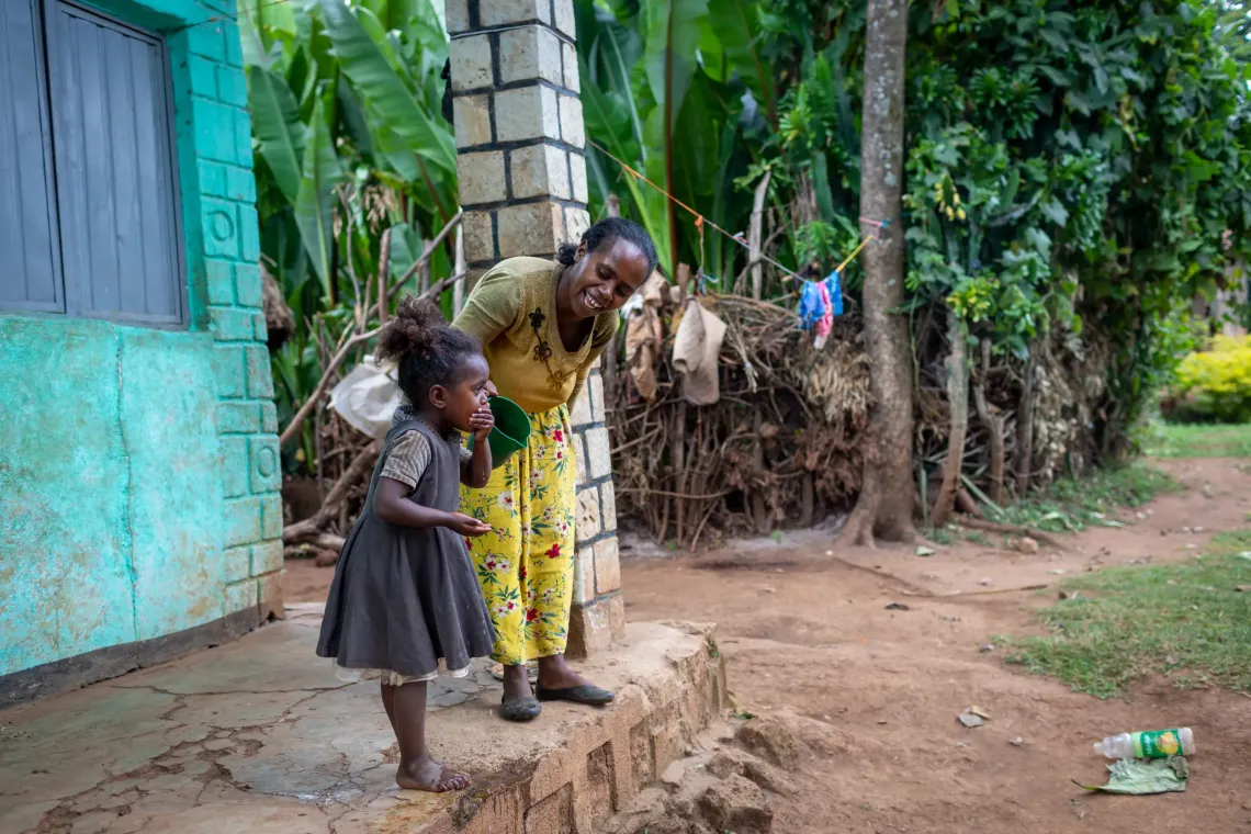 A mother helps her child wash her face