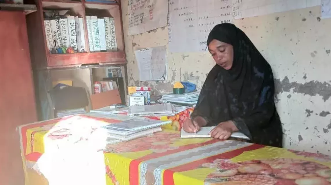 Seada Addisu writing in her office at Geriro Primary School.