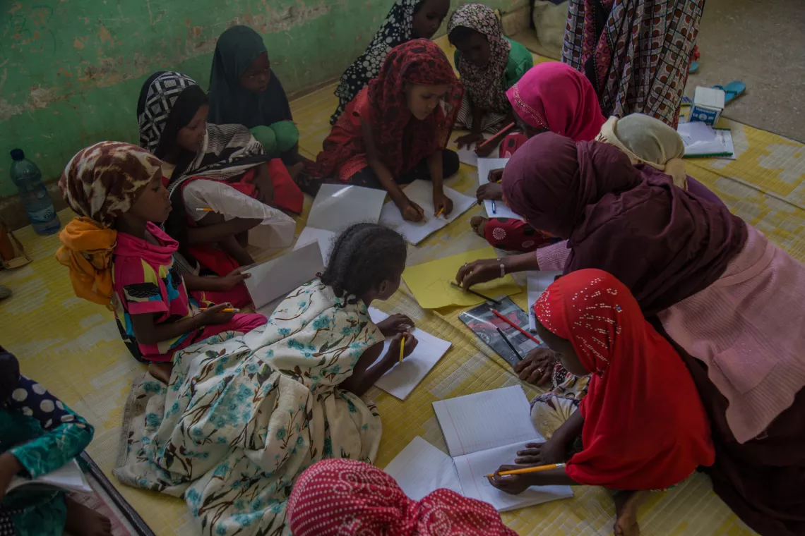Children in the ASR program at Simbile Primary School work on their class activities with their teacher, Afar Region