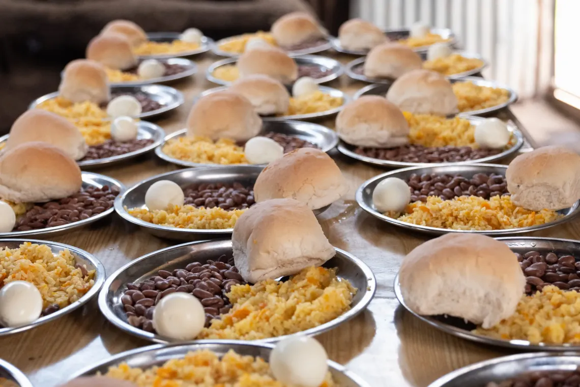 A lined up of plates with rice , boiled egg and vegetables. 