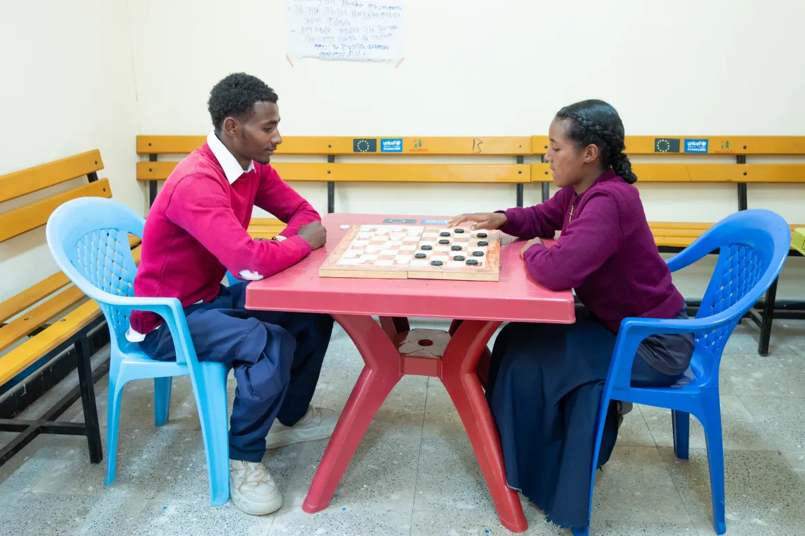 A young man and young women playing board game