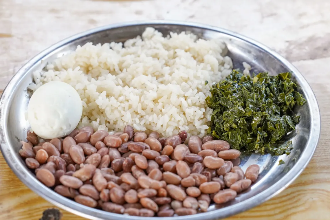 A close up of a plate full of rice, vegetable and boiled egg. 