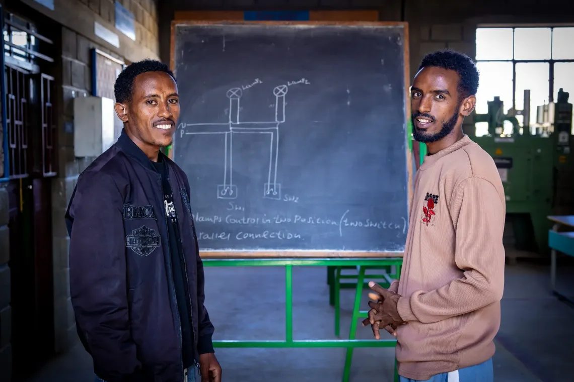 Gebremedhin, 26, a participant in Biqu Wetat and his sign language interpreter standing infront a blackboard