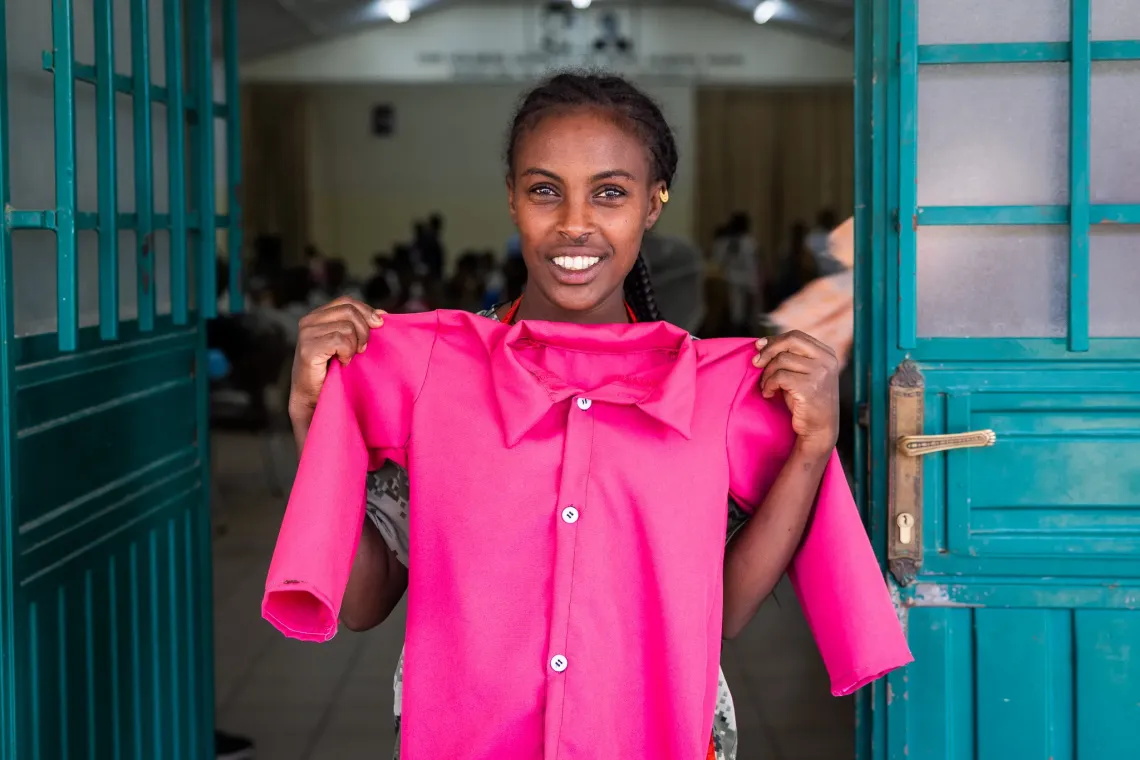Tirhas, 29, holding up a shirt she made in the Biqu Wetat training center. 