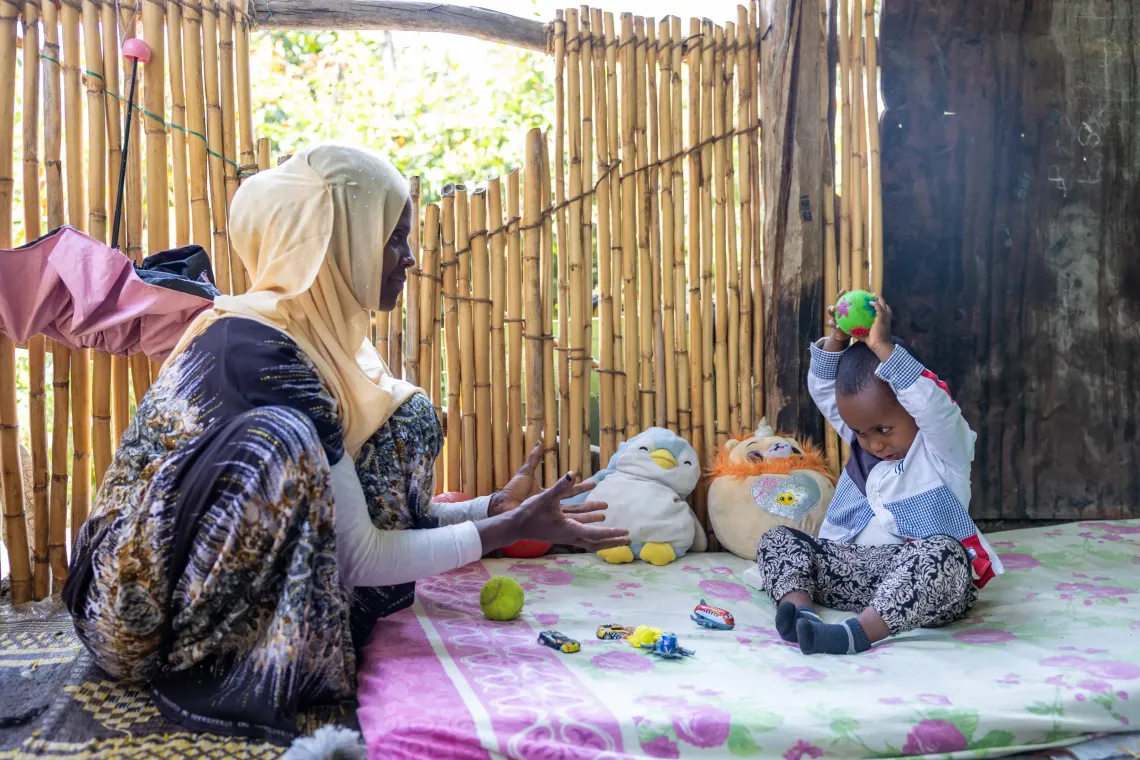 A mother play ball with her toddler