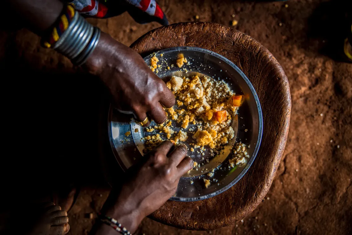 Close up of two hands eating a meal from the same plate