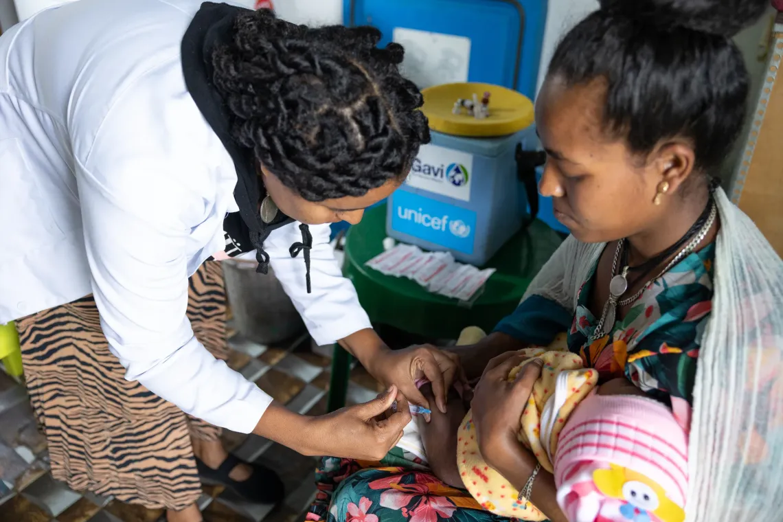 A child is being vaccinated while his mother is holding him. 