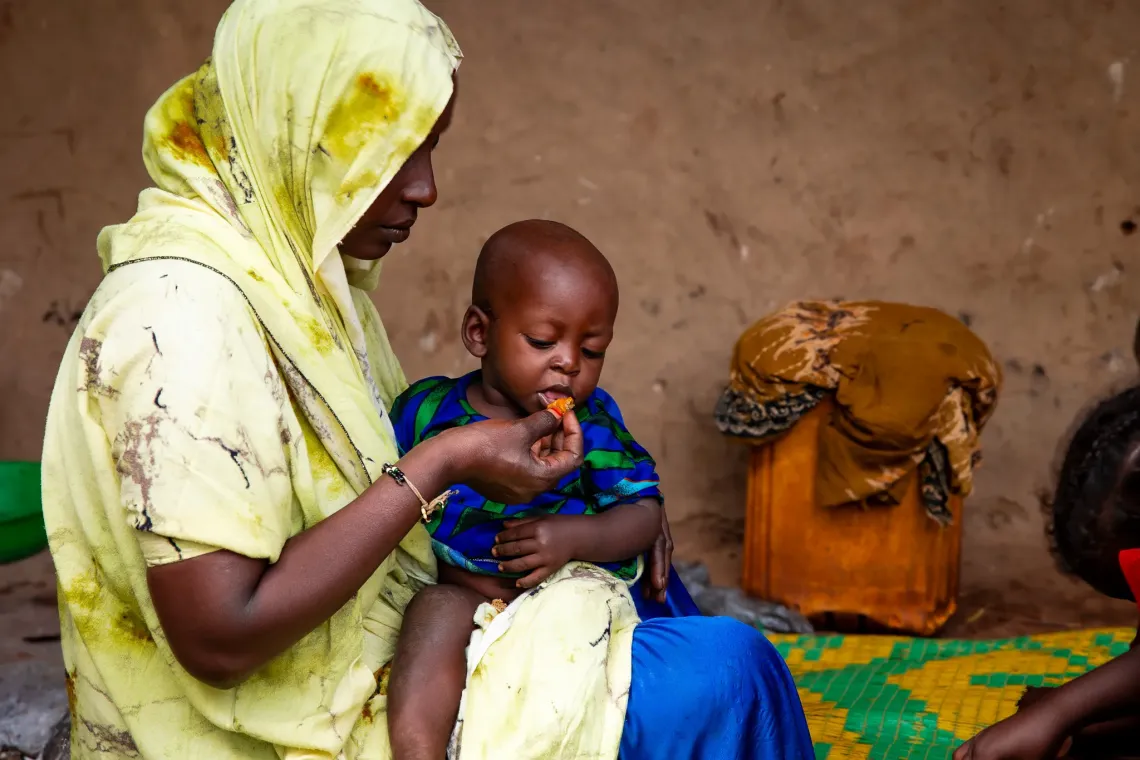 Teyiba feeding her child.