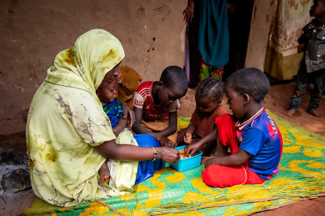 Teyiba eating with her children