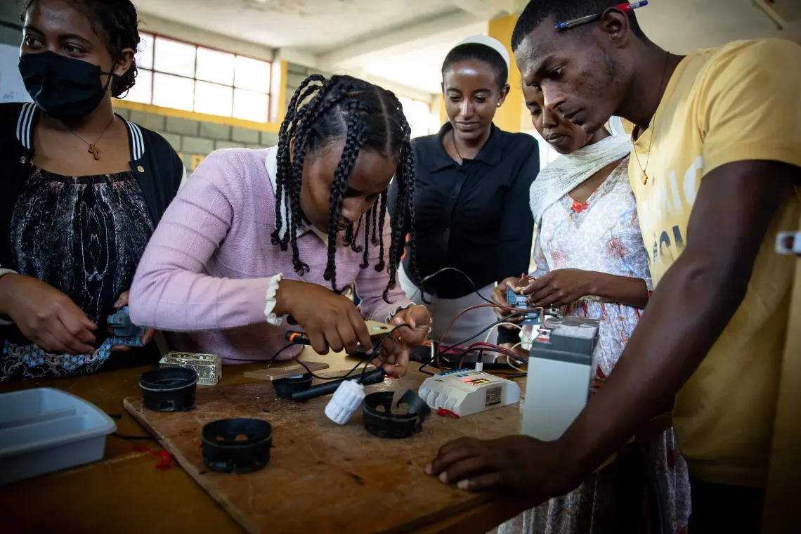 Trainees at the Biqu Wetat training center working on solar battery equipment.