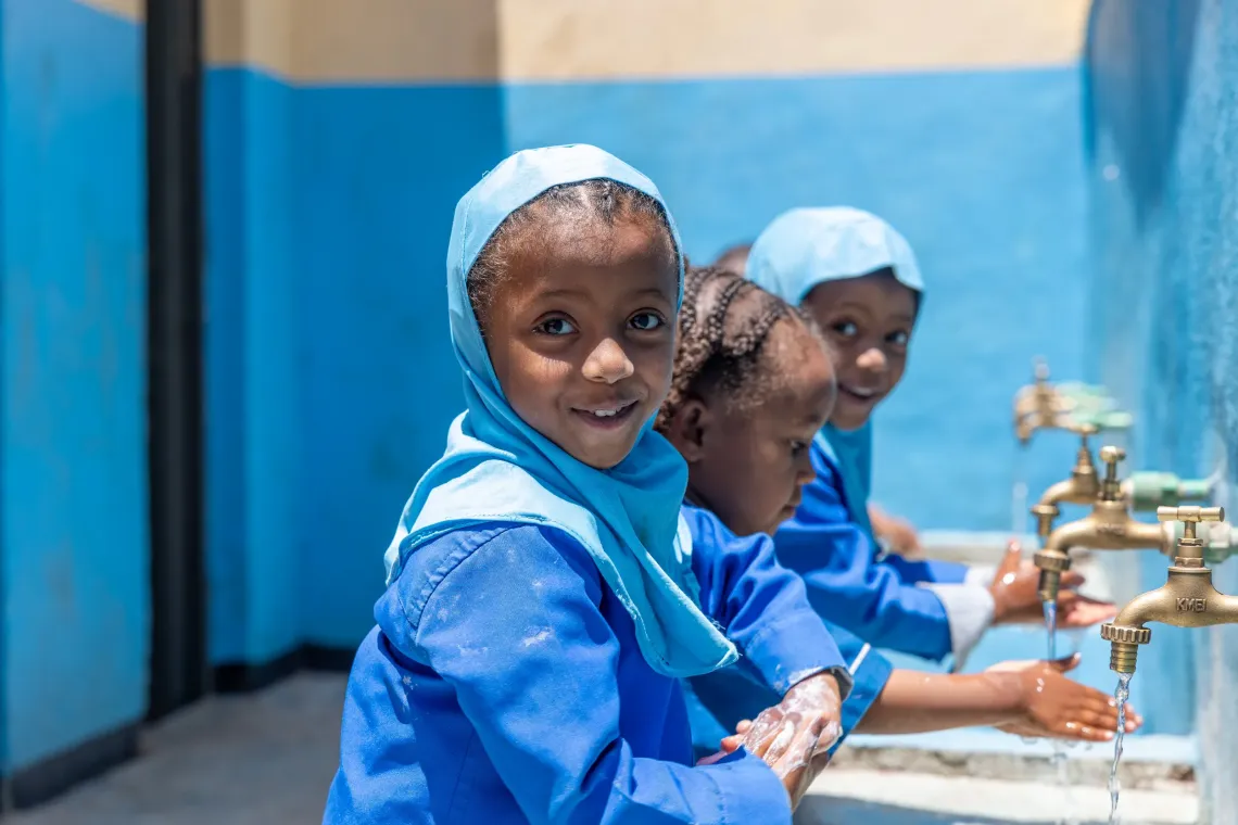 Kindergarten children washing their hands with water and soap 