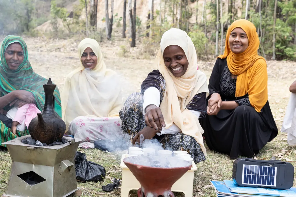 A women burn incense while making coffee. 