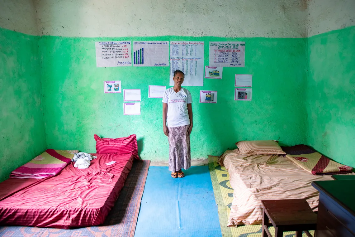 Workalem stands in a room with mattresses laid on her left and right side. The room is where girls rest during their period. 