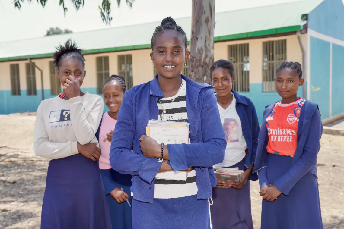 A young girl standing firm with her friends in the back