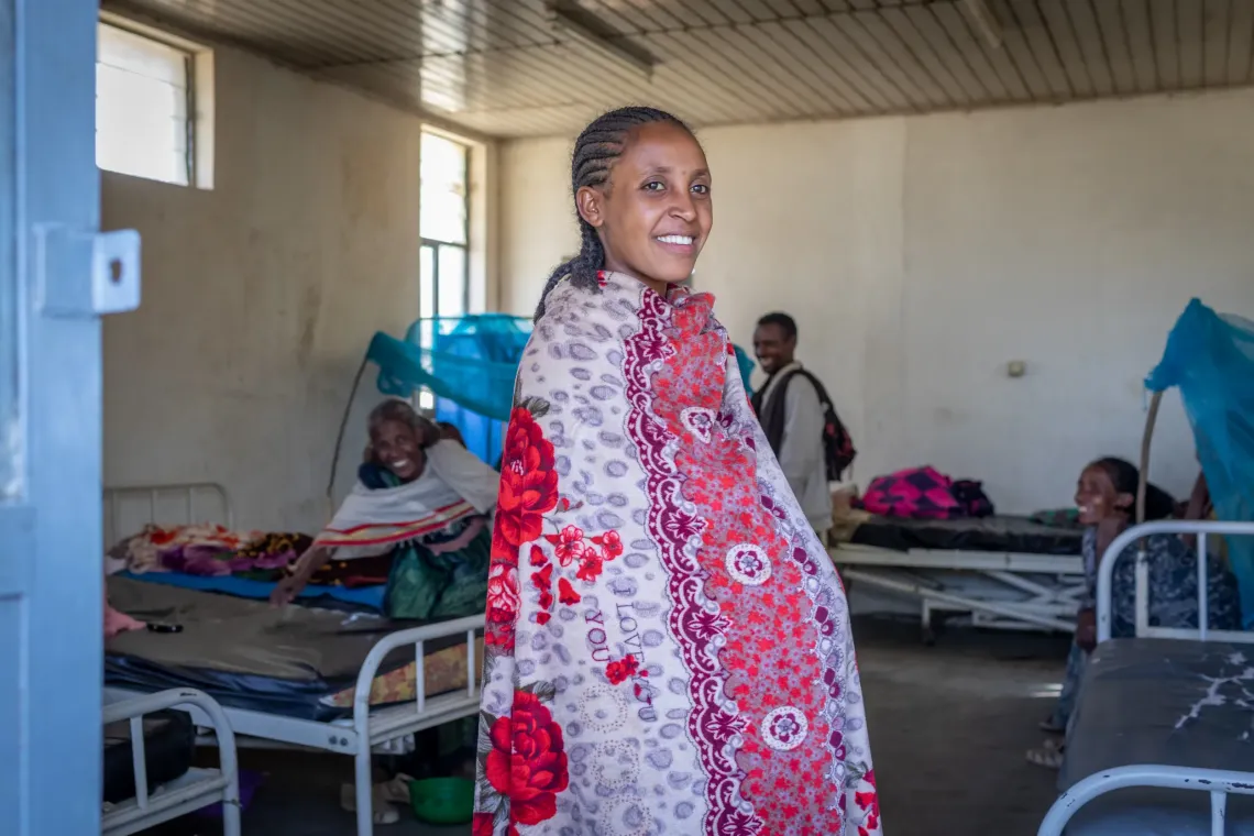 A pregnant mother standing straight and posing for the camera